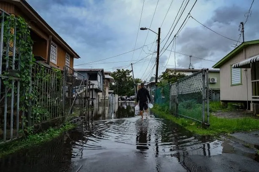 Une personne marche dans une rue inondée à la suite de l’ouragan Fiona