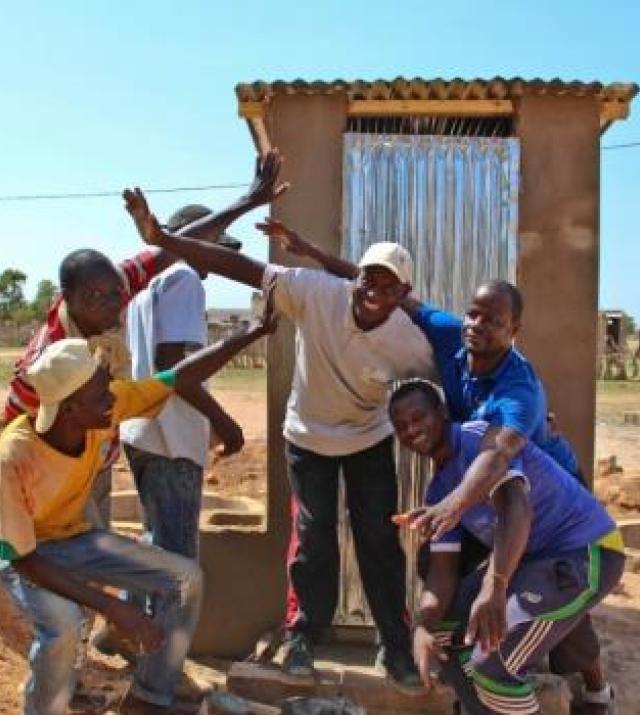 men in front of latrine