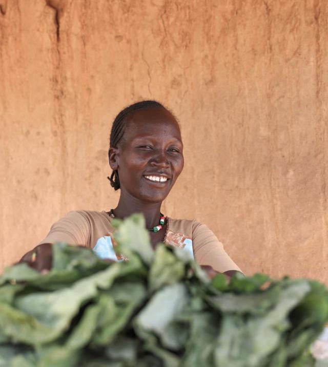 photo of a woman smiling behind a market stall