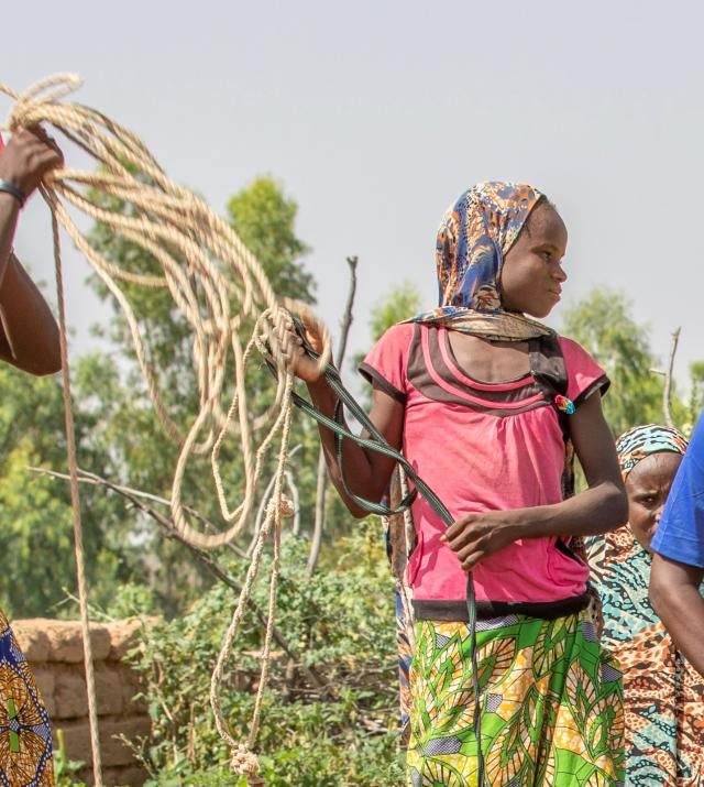 Women holding rope in a field