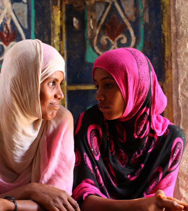 Deux femmes yéménites assises côte à côte, se regardant