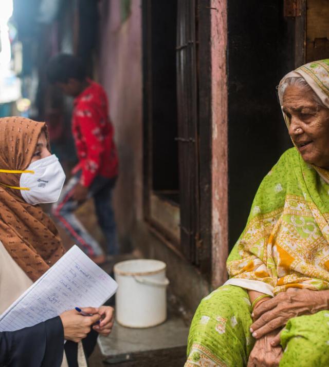 Community health worker speaks with a woman in Mumbai