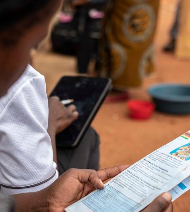 A woman examines a child health card during the COVID-19 pandemic in Zimbabwe