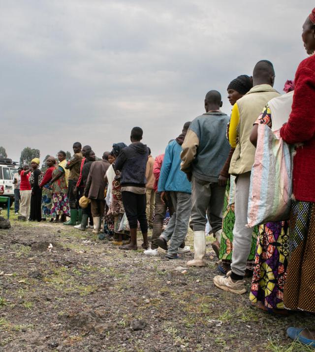 A group of people line up outside a distribution center in Eastern DRC