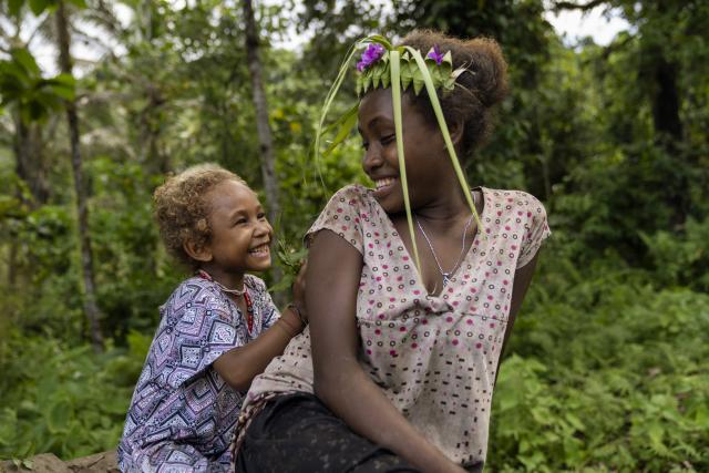 Lucy, quatre ans, joue avec Joyce, 13 ans, dans une communauté isolée de la province de Malaita, aux Îles Salomon